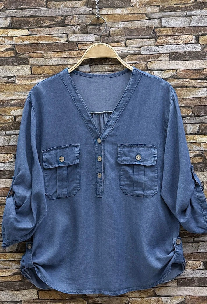 Blue shirt on a hanger against a stone wall background