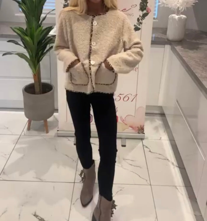 Person wearing a Adriana Jacket, black pants, and brown boots in a store setting.