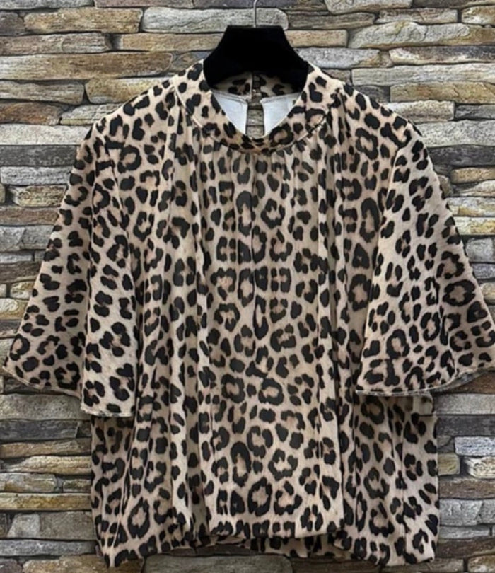 Leopard print jacket on a mannequin against a stone wall background
