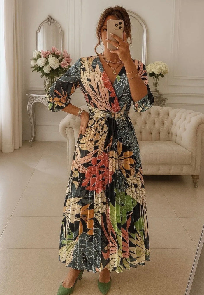 Woman taking a mirror selfie wearing a Angelique Print Dress in an elegant room.