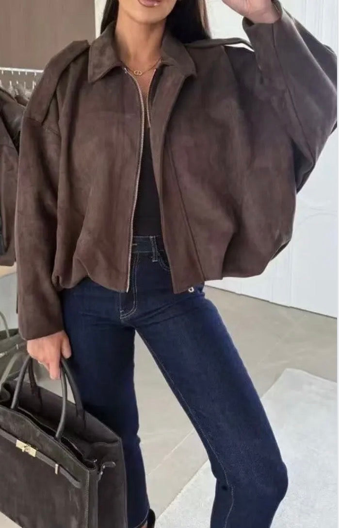 Person wearing a brown Annie Suede Effect Jackett and dark jeans, holding a black handbag.