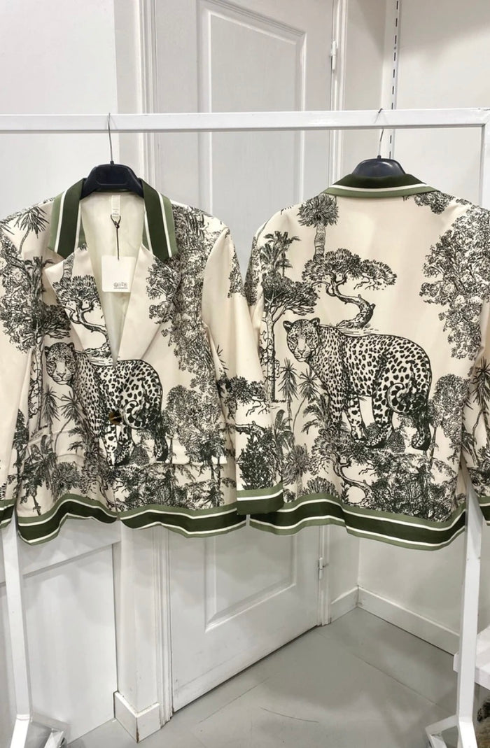 Ashley Print Blazer with animal designs on hangers against a white wall.