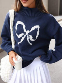 Navy blue sweater with a large white bow design worn by a person. "Betty Bow Detail Knit"