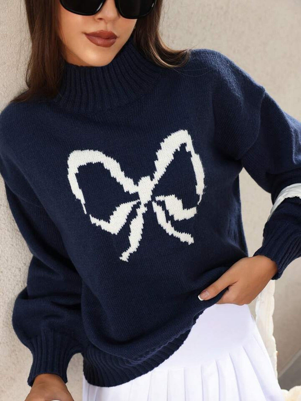 Navy blue sweater with a large white bow design worn by a person. "Betty Bow Detail Knit"