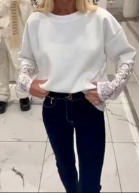 Person wearing a Kelsey lace top and dark jeans on a marble floor.
