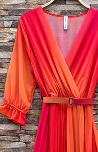 Orange dress with a belt against a wooden wall background