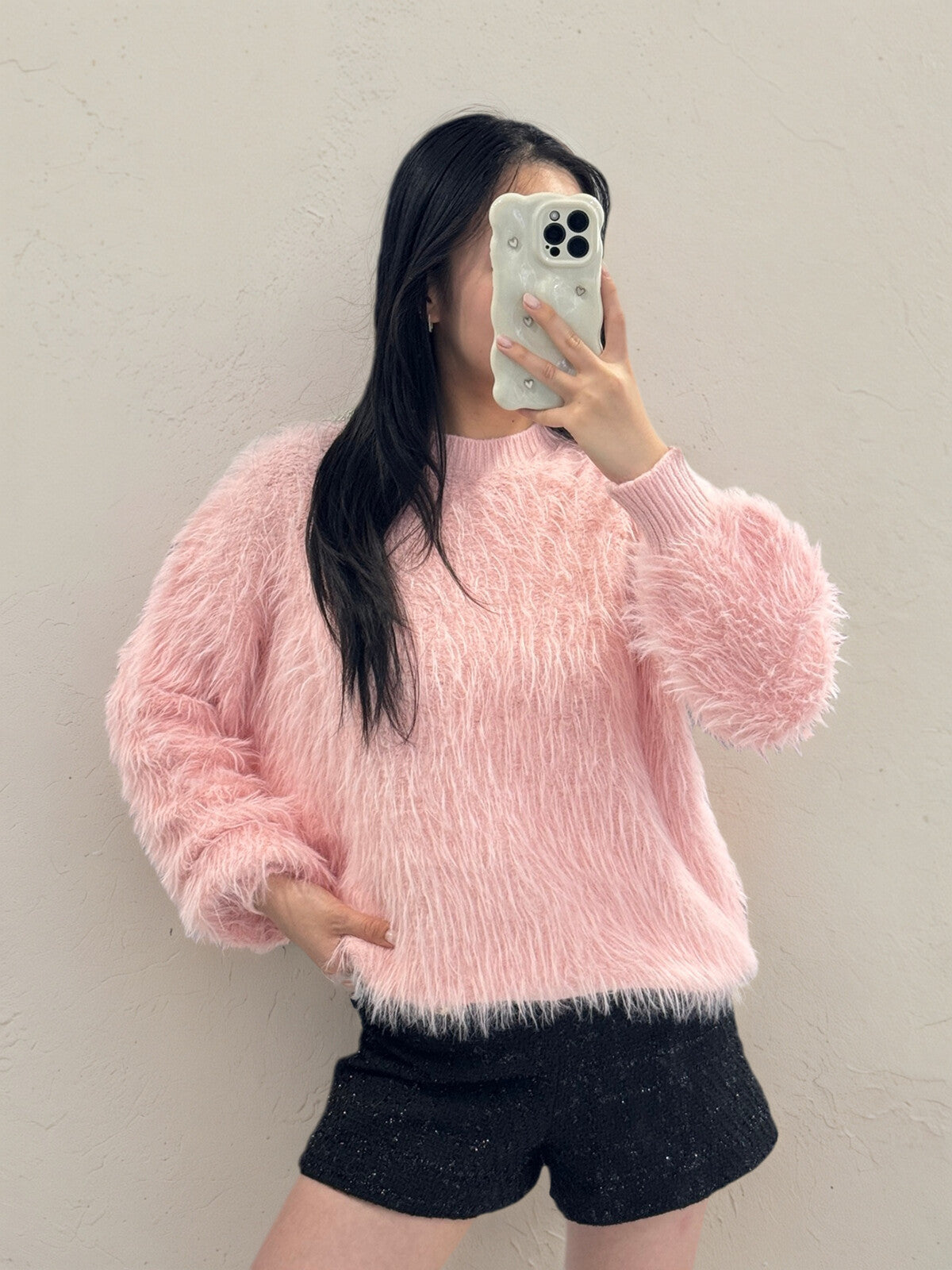 Person wearing a Chloe Fluffy Jumper sweater taking a mirror selfie.