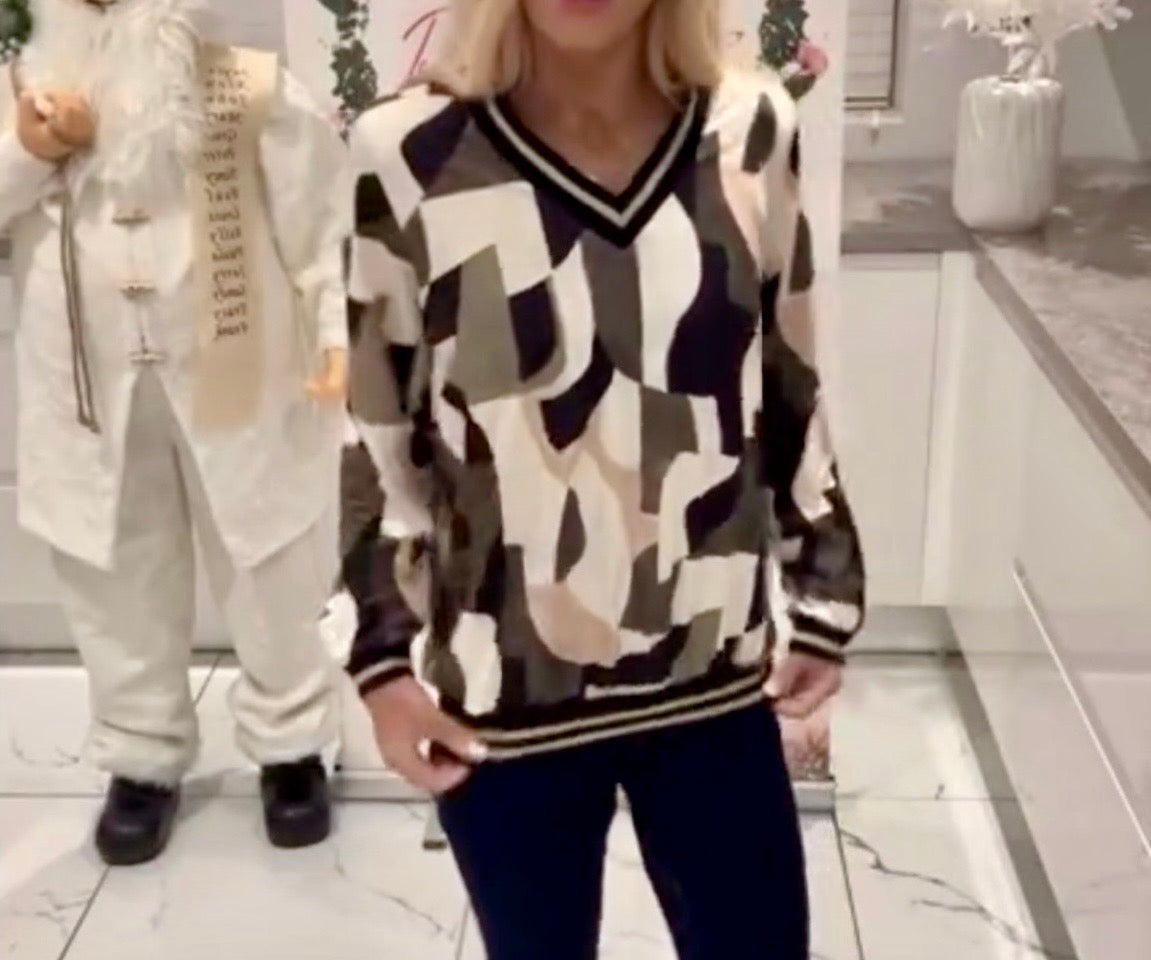 Person wearing a Cindy Metallic V-Neck Print Top in a room with a mannequin and decorative items.