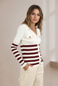 Woman wearing a white sweater with red horizontal stripes and beige pants against a plain background "Cindy Stripe Knit"