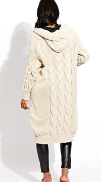 Person wearing a long cream cable knit cardigan on a white background