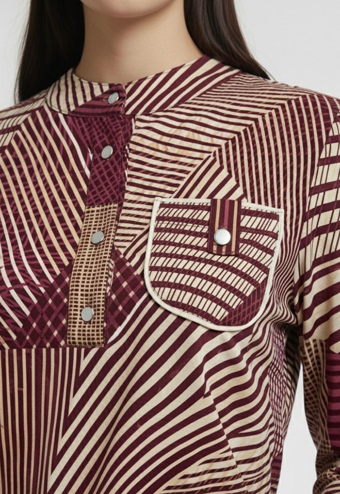Close-up of a patterned shirt with maroon and beige colors on a plain background