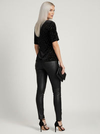 Woman wearing a black studded top and black leather pants on a white background Joyce Sparkle Detail V-Neck Top – Elegant Party Blouse
