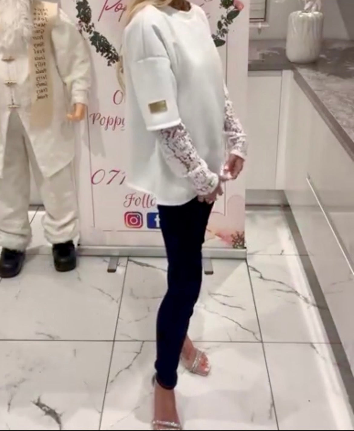 Person wearing a Kelsey lace top with lace sleeves in a store setting.