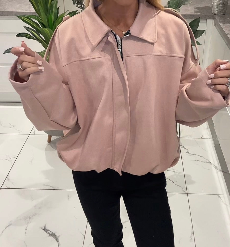 Person wearing a light pink jacket indoors on a marble floor.