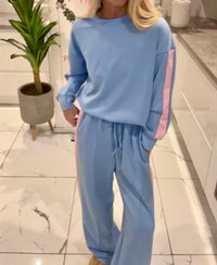 Person wearing a light blue Melissa_Lounge_Set with pink stripes in an indoor setting.