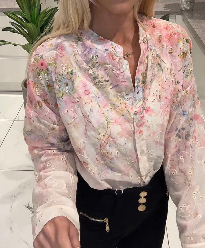 Floral blouse worn by a person with a blurred background