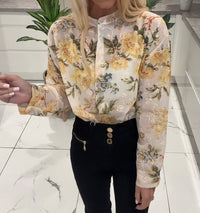 Person wearing a floral blouse with a blurred indoor background