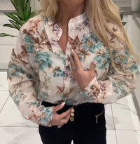 Woman wearing a floral blouse with a blurred background