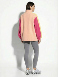 Person wearing a colorful jacket and gray leggings on a white background
