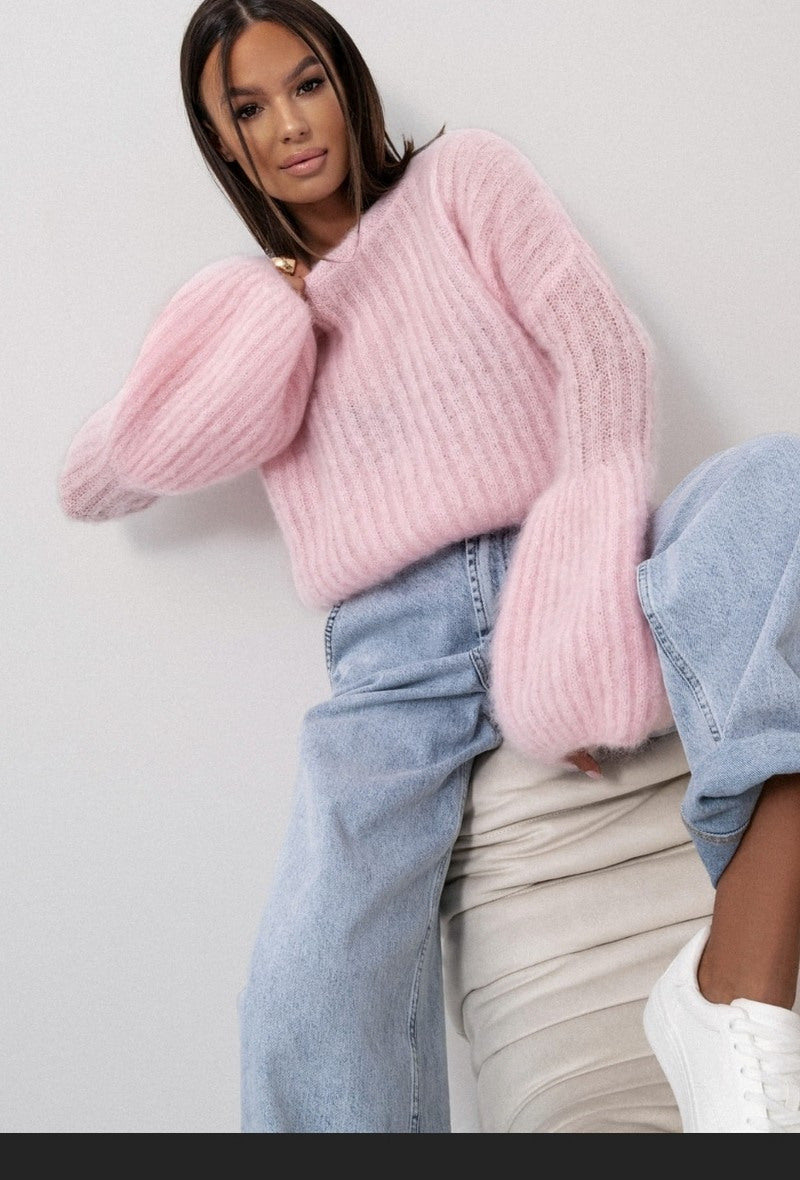 Person wearing a pink Rachel Fluffy Knit pink and light blue jeans against a plain background