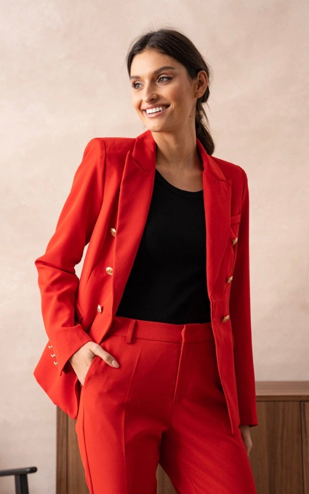 Woman wearing a Rita Red Gold Button Blazer with a black top against a neutral background