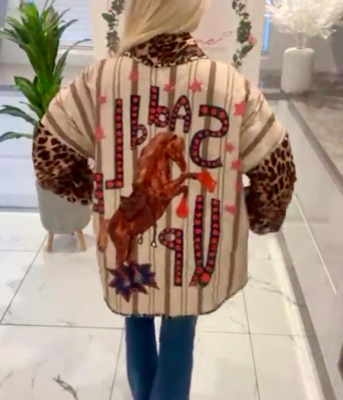 Person wearing a patterned Sadie Jacket Stylish Women’s Jacket with text and graphics in an indoor setting