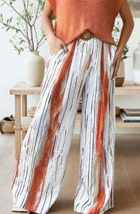 Person wearing a sleeveless top and wide-leg pants with a striped pattern in a home setting.