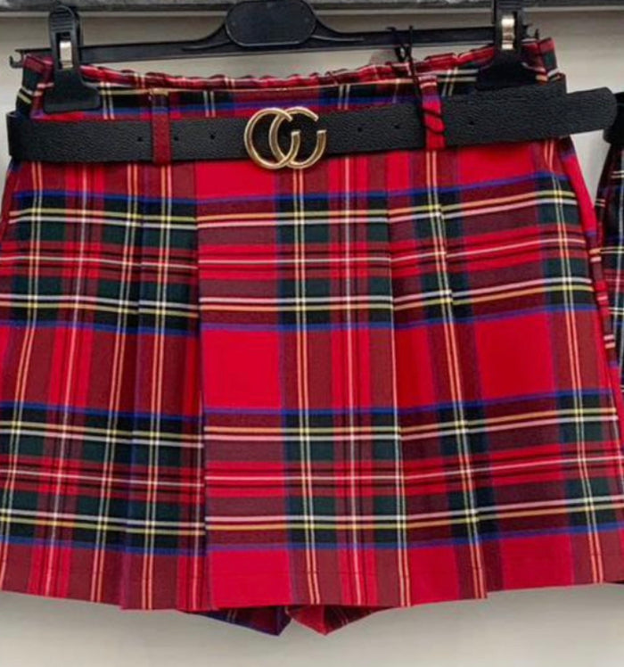 Red plaid skirt with a black belt featuring a gold buckle on a hanger.