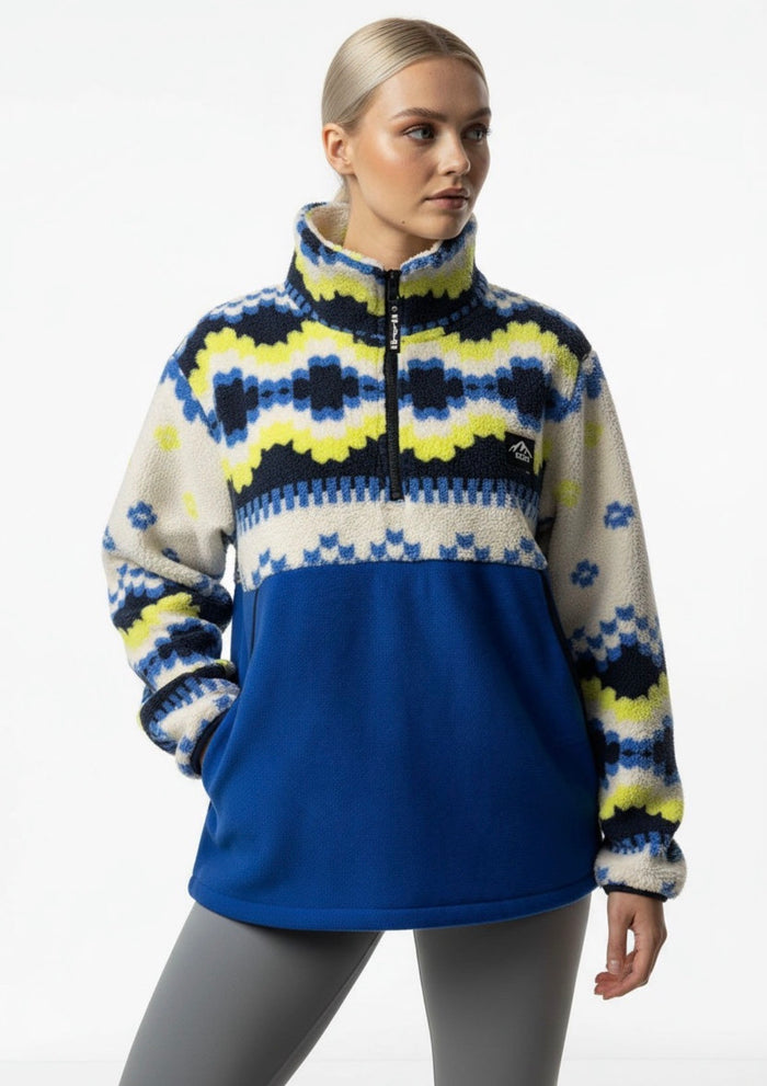 Woman wearing a colorful patterned sweater with a blue base on a white background