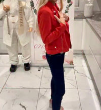 Person wearing a red Ivy Suede Detail Biker Jacket  and dark pants standing on a marble floor.