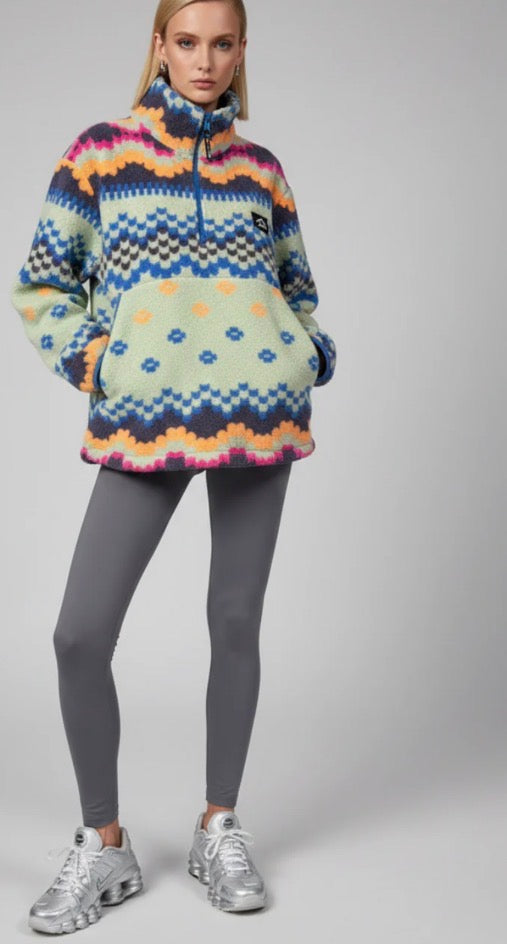 Person wearing a colorful trek fleece mint & blue and gray leggings on a plain background