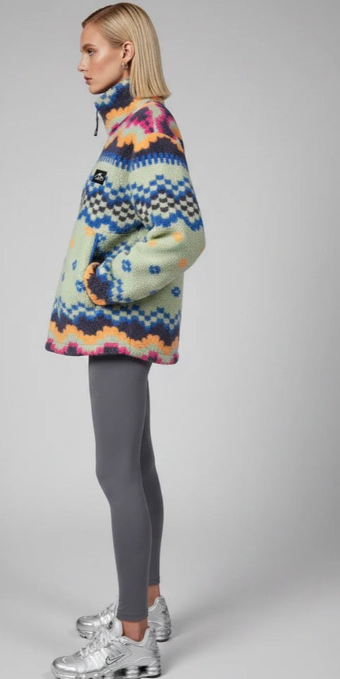 Person wearing a trek fleece mint & blue on a gray background